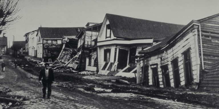 Subcategoría riesgos socionaturales: hombre caminando entre casas destruidas para el terremoto de Valdivia, año 1960, Chile.