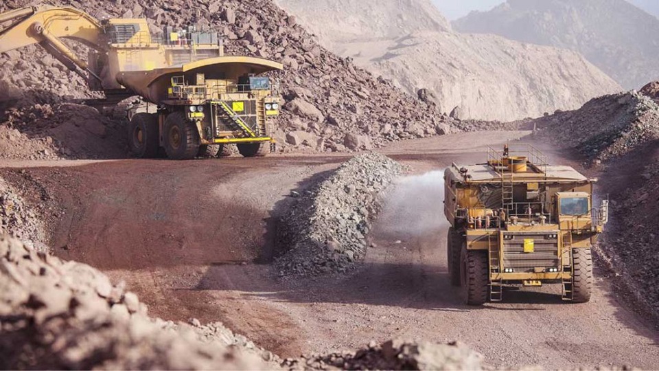 Fotografía donde se observan grandes maquinas que operan dentro de una minera