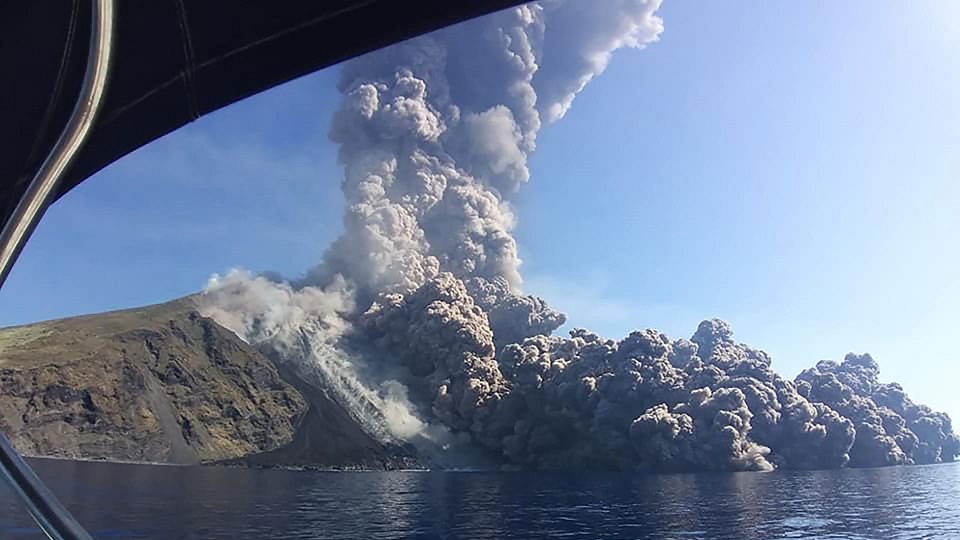 Imagen de una erupción volcánica, mucho humo saliendo desde las laderas del volcán cayendo en el mar
