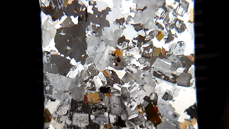 Fotografía de una lámina de un corte de roca vista con el microscopio del profesor